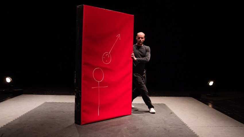 Sur le plateau, le porteur se cache derrière le tapis rouge couvert de dessins.